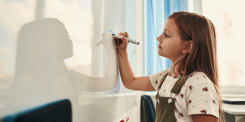 confident-child-student-writing-on-whiteboard-during-one-to-one-tuition