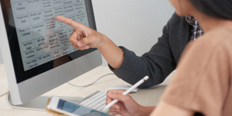 Older-student-receiving-English-tuition-with-tutor-whilst-looking-at-notes-on-computer-screen