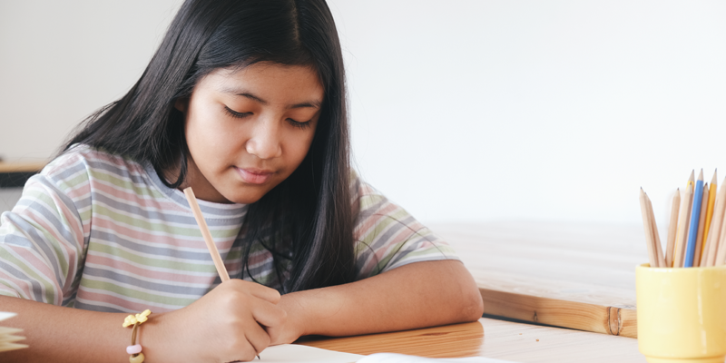 student-working-at-home-writing-on-paper-doing-work-for-home-tuition